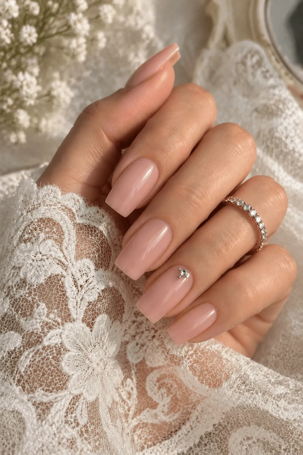 Acrylic Nail Ideas for a Wedding Soft nude acrylic nails with a small rhinestone accent for a wedding