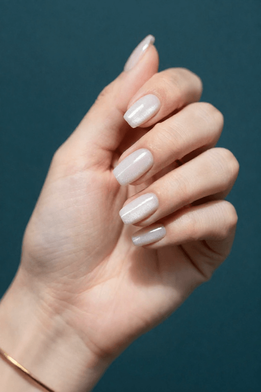 Almond nails in white cat-eye gel with a shimmer line across each nail