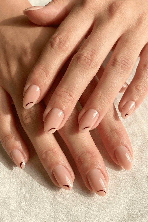 Comma Strokes Comma Strokes: Short round beige nails with three small curved dark brown comma strokes on each accent nail