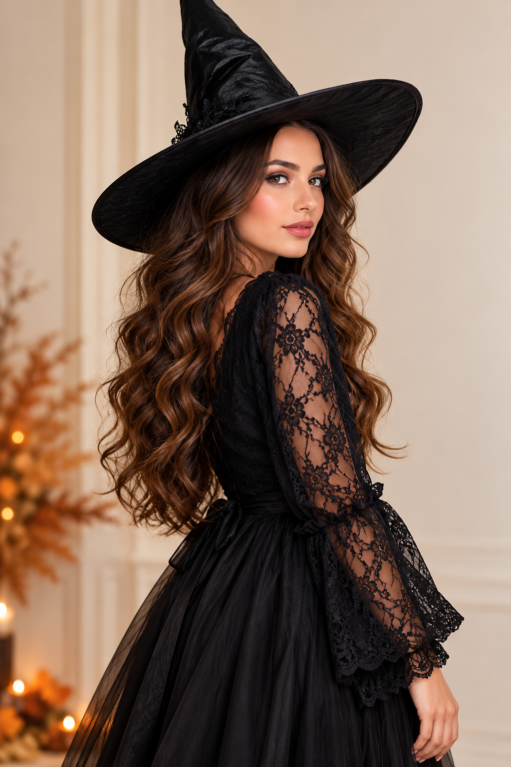 Woman in a tall black witch hat and a black lace-sleeve dress with long brown waves, Halloween costume idea for women