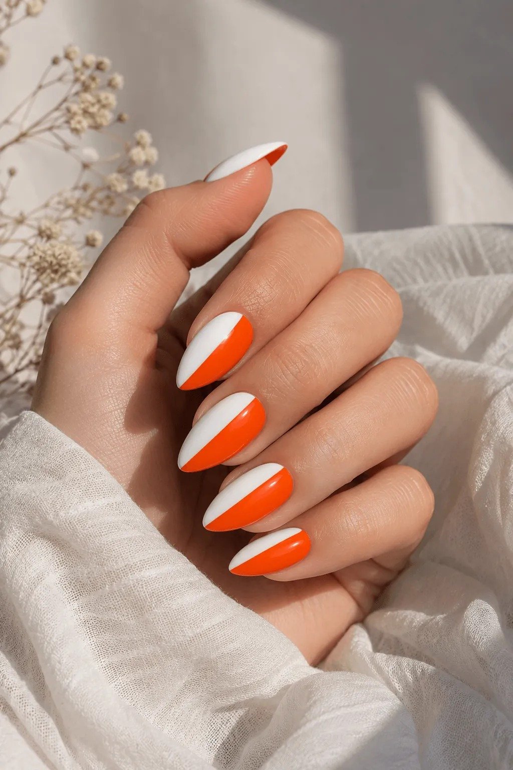 Almond nails with a bright orange and white split design, Halloween nail colors