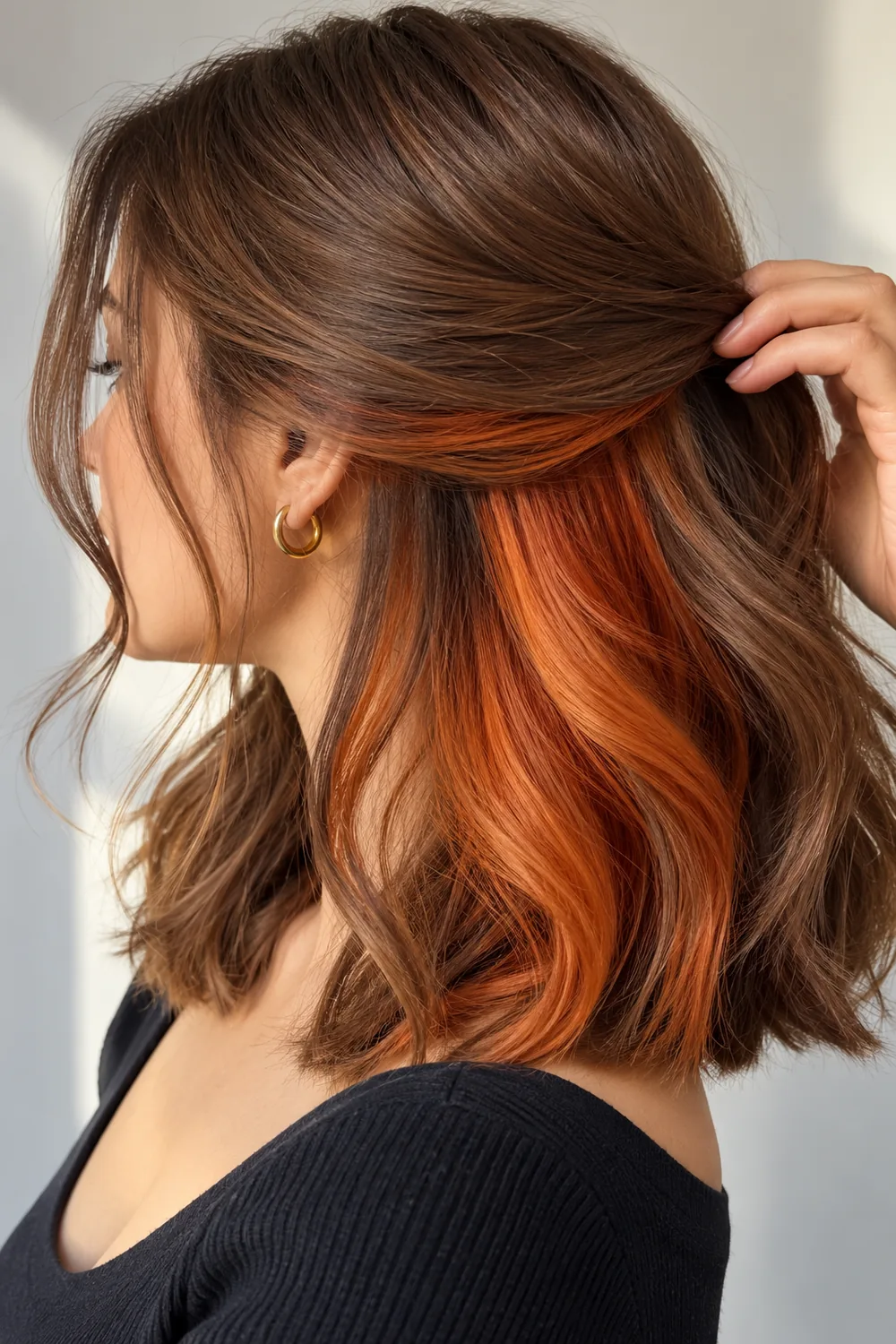 Copper orange peekaboo hair under light brown hair