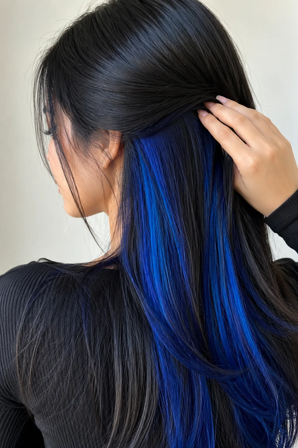Electric blue peekaboo hair color under a black top layer
