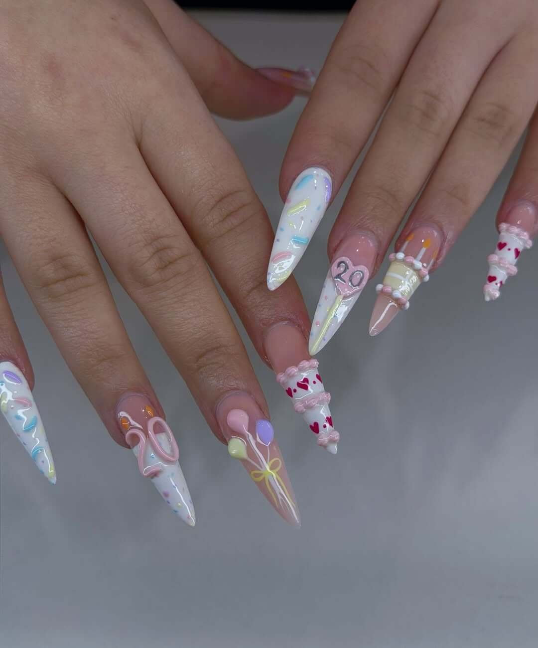 linz_nailslux8 Pastel Balloons, Sprinkles and Age 20 on Long Stiletto Nails Long stiletto nails with pastel balloons, sprinkle lines, a mini cake, and an age number
